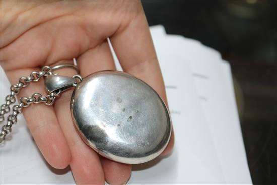 An Indian white and yellow metal oval locket embossed with a deity, on a white metal chain, locket 5cm.